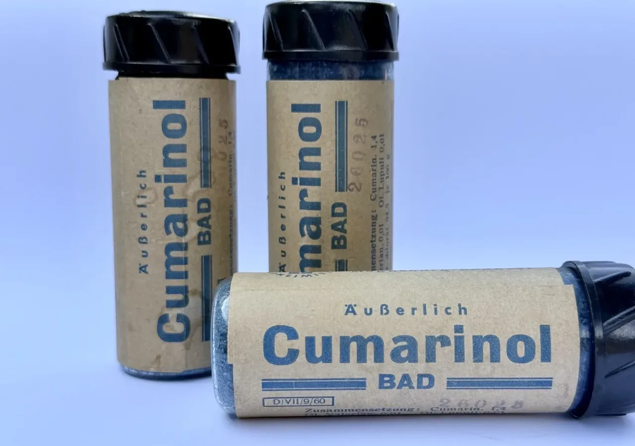 Drei historische Röhrchen des Badezusatzes „Cumarinol Bad“ mit blauer Aufschrift auf braunem Etikett, Vorderseite, Fund aus dem Stadtbad Lichtenberg