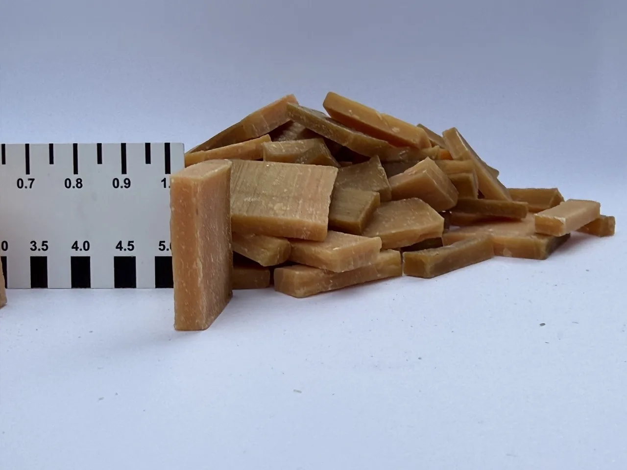 Stücke der Millimeterseife neben einem Zentimeter-Maßstab, der die geringe Höhe der einzelnen Seifenportionen erkennen lässt